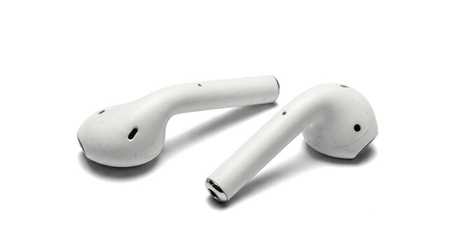 realistic photograph of two white wireless earbuds, close-up studio shot against a transparent background, highlighting their modern design and portability for personal audio.