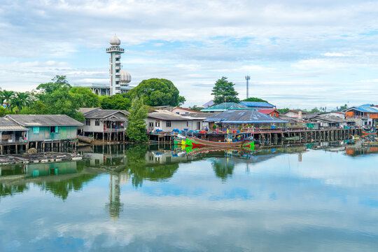 Local fishing village along the Bang Nara River with kolae boats colorful with a mosque in the background in the evening.