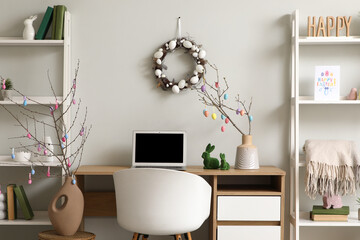 Interior of office decorated for Easter with workplace and shelf units