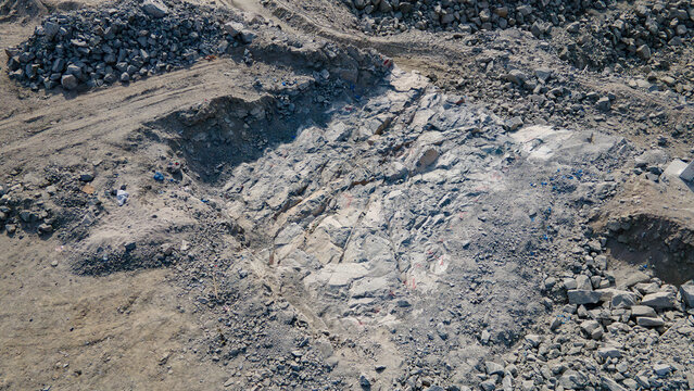 Aerial view of exposed bedrock and rock excavation during hydropower dam foundation construction.