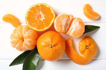 Obraz premium Sweet mandarins and leaves on white wooden background