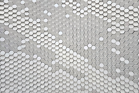 A full-frame background of a modern architectural wall featuring a repeating hexagonal honeycomb pattern.