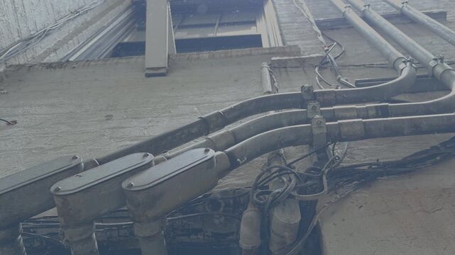 Weathered Electrical Wiring Conduits Dripping in Light Rain