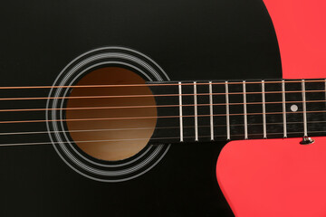 Fototapeta premium Modern black guitar on red background, closeup
