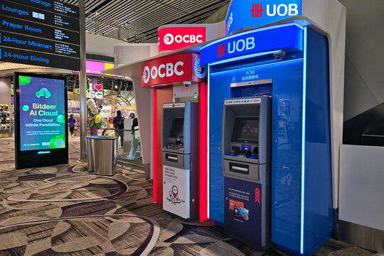 Changi, Singapore - Jan 21, 2026: Row of OCBC and UOB automated teller machines "ATM" in the Terminal 2 transit area.