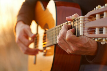 Obraz premium Jazz Day Close up of hands playing acoustic guitar with warm golden light image