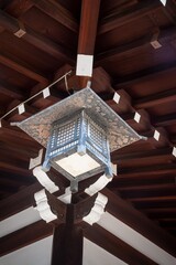 Obraz premium Traditional japanese hanging lantern beneath dark wooden temple ceiling with carved beams