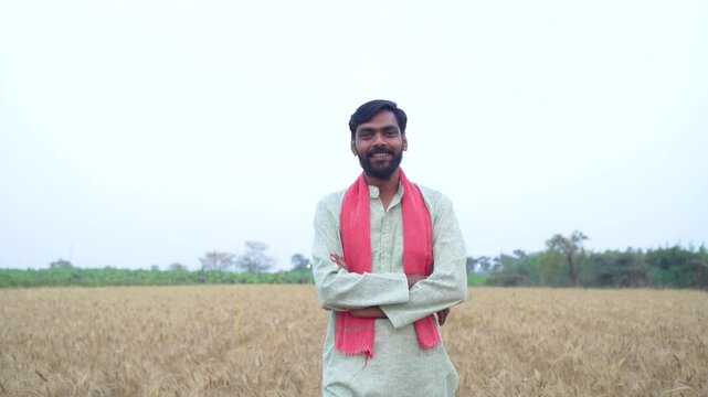 Young Indian farmer standing at wheat agriculture field 