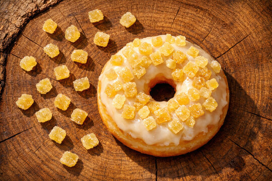 Donut glaseado de jengibre, rosquilla dulce con trozos de jengibre confitado, postre de panader&iacute;a artesanal sobre madera r&uacute;stica, dulce tentaci&oacute;n para cafeter&iacute;as y blogs de comida