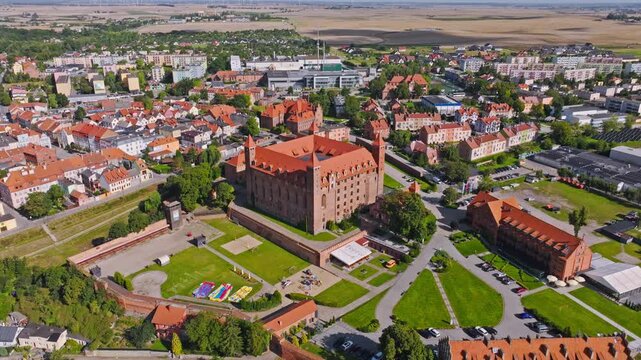 Aerial drone retreat captures Gniew castle and town glowing in clear summer sun