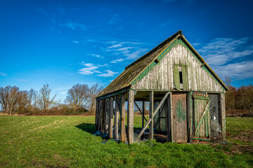 eine alte Holzhütte auf einer Wiese