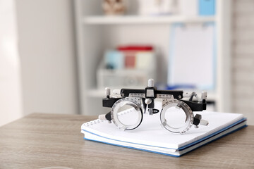 Ophthalmic trial frame with notebook on medical student's table in clinic, closeup