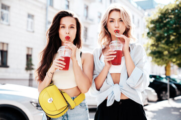 Two young beautiful smiling glam female in trendy summer clothes. Sexy women posing outdoors....
