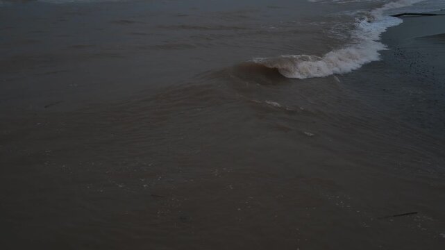 海水と河口の茶色い水の混じった波打ち際