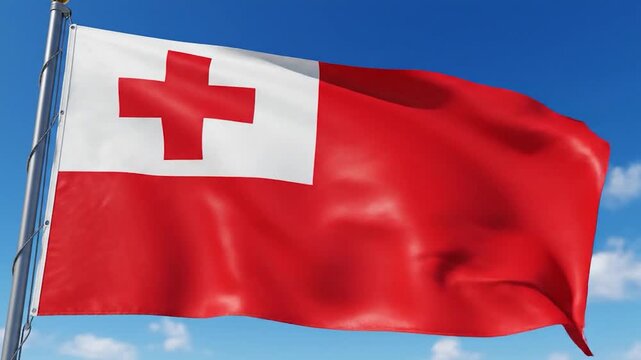 The national flag of Tonga proudly waves against a clear blue sky with white