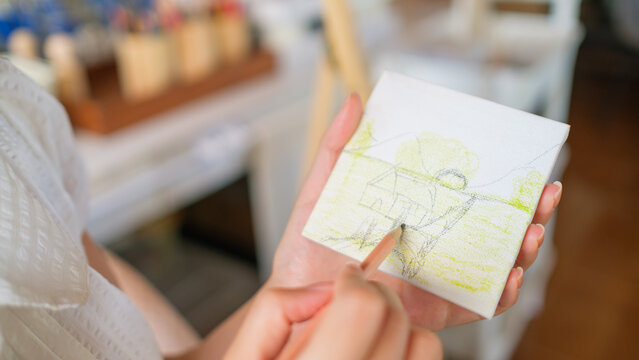 Close up of an artist painting on small white canvas in a workshop, handmade art and craftsmanship.