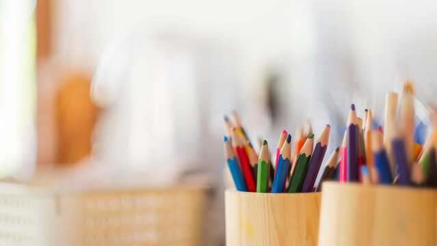 Art and crafts color pencil crayons in a jar, artist workshop equipment and tools, white copyspace.