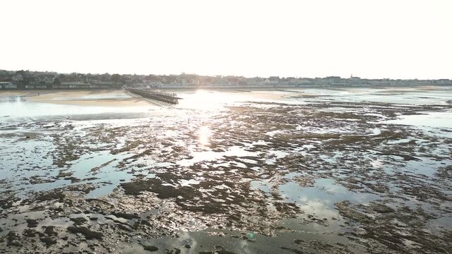 aerial drone view of the coastline at Luc-sur-Mer in Normandy, France, during low tide.