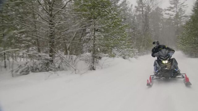 An adventurous ride with a snowmobile through the snow covered forests.