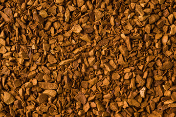 Macro instant coffee granules forming brown textured food background