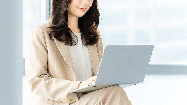 ノートパソコンを操作する女性ビジネスパーソン, Businesswoman using a laptop computer