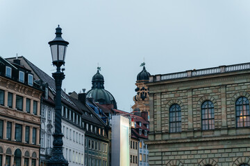 Fototapeta premium Historic European architecture featuring iconic cathedral towers and traditional buildings in Munich city center. A perfect travel and tourism image capturing culture, heritage, and urban atmosphere
