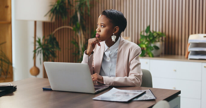Black woman, laptop and thinking in office for lawsuit research, case preparation and drafting legal report. Business attorney, employee and technology for online court review, planning and email