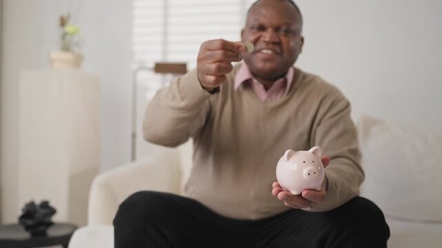 Good mood of black man saved money, african person putting coins into piggy bank . Save up money for retirement and wishes, financial literacy of modern people, economic crisis, householder save money
