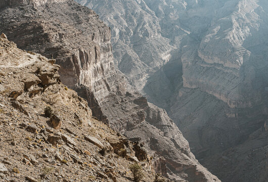 Tiny figure on a ledge on the balcony trail near Jebel Shams, Oman