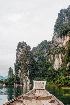 Boat approaching limestone karst cliffs in Cheow Lan Lake, Khao Sok