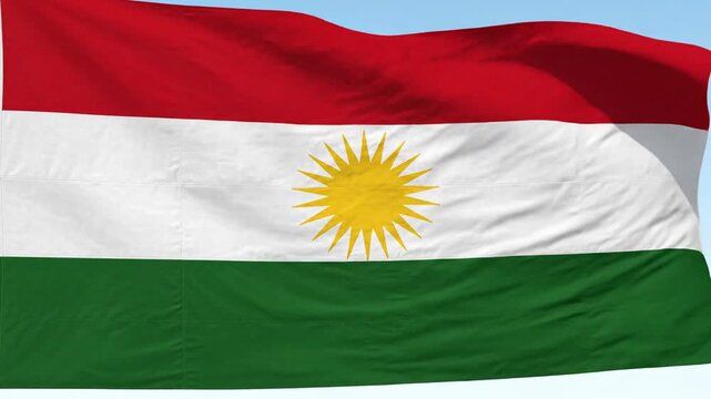 Waving Kurdish Flag with Sun Symbol on Blue Sky Background
