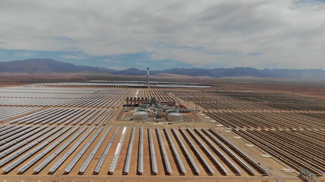 Aerial view of concentrated solar power tower and mirror fields at Noor solar complex in Ouarzazate Morocco highlighting renewable energy technology in the desert.