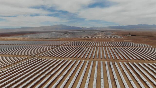 Aerial view of long solar mirror rows stretching across the Noor solar power complex in Ouarzazate Morocco highlighting large scale renewable energy in the desert.