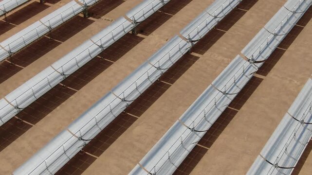 Close aerial view of parabolic trough solar thermal collectors at Noor solar power plant in Ouarzazate Morocco showing renewable energy technology in the desert.