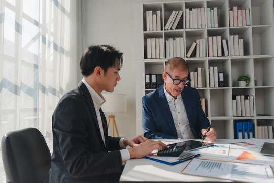 Businessmen collaborating calculating financial data in modern office