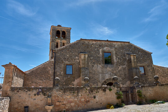 Ancient stone church of San Juan Bautista in Pedraza, Segovia, under clear skies