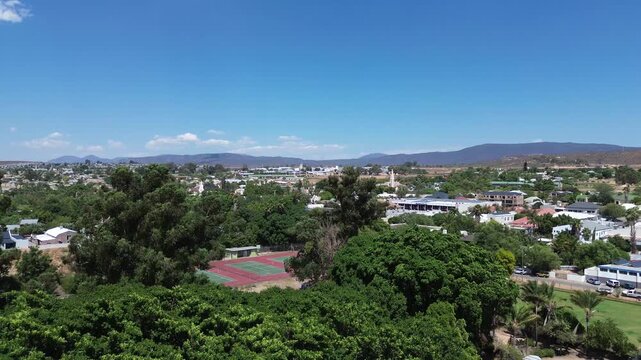 Camera rising up to reveal the town of Clanwilliam with mountains on the horizon. The town is Famous for Rooibos tea and fruit. 4K Aerial Video.
