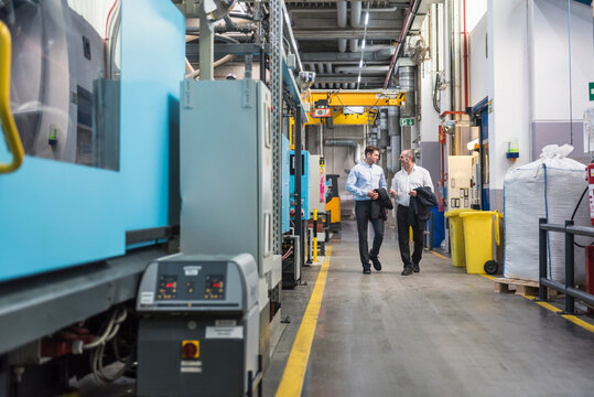 Two men walking and talking in factory shop floor