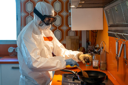 Woman wearing protective clothes, cooking in kitchen