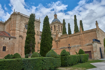 Obraz premium Detailed view of the Romanesque tower of Ciudad Rodrigo Cathedral in Salamanca, with a cloudy sky and green trees in the foreground