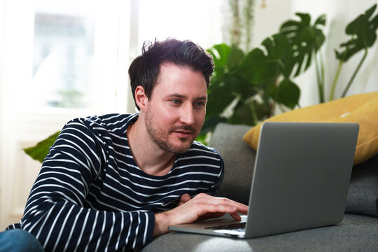 Man sitting at home, using laptop