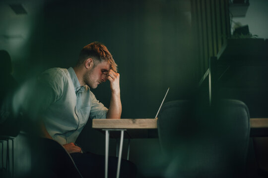 Tired man sitting in office, working late in his start-up company