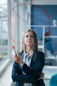 Young busnesswoman drawing a pie cahart on a glass screen