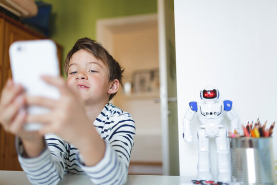 Boy doing homeschooling and using smartphone at home