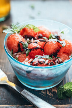 Watermelon salad with eschalot, mint, olive oil and balsamico in bowl