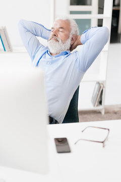 Mature man with beard relaxing at desk