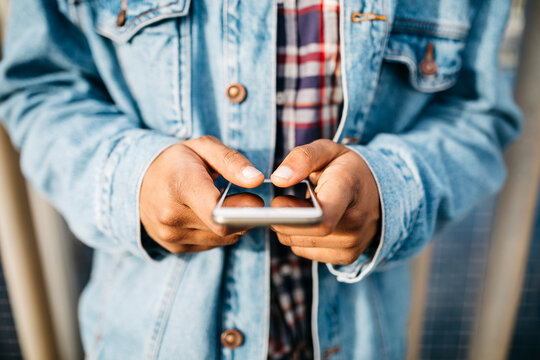 Man's hands text messaging