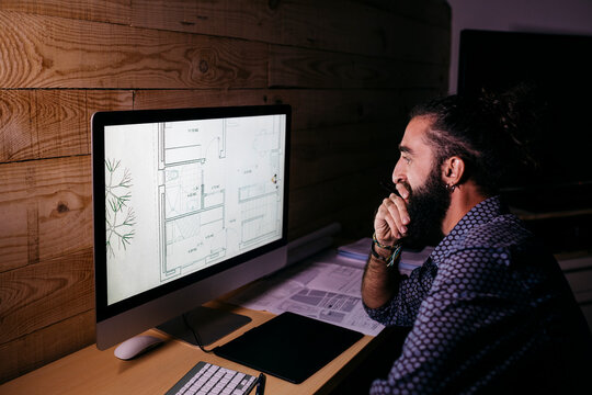 Young architect working hard on a new project at home at night