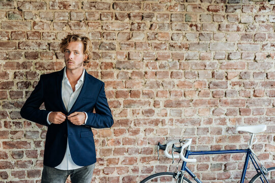 Portrait of businessman buttoning jacket