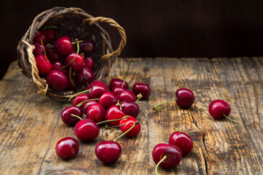 Wickerbasket of cherries on wood